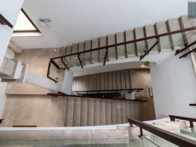 Il luminoso vano scala unisce la moderna ringhiera in vetro e metallo...